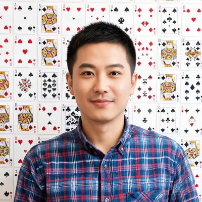 团队核心成员王鹏，男性，30岁左右，穿格子衬衫，背景有扑克牌墙贴